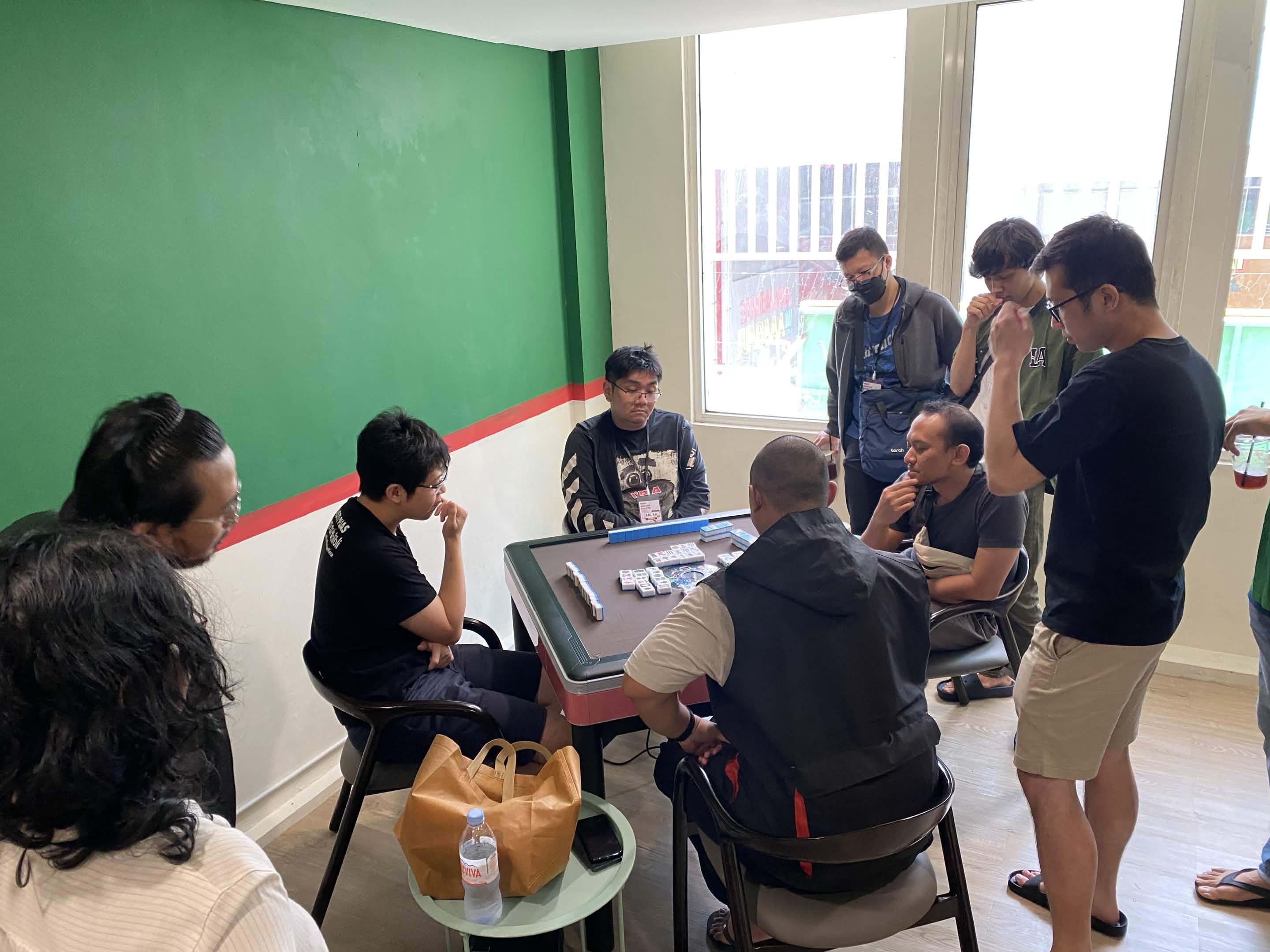 Anggota SURIMA berkumpul mengelilingi meja mahjong sambil berdiskusi